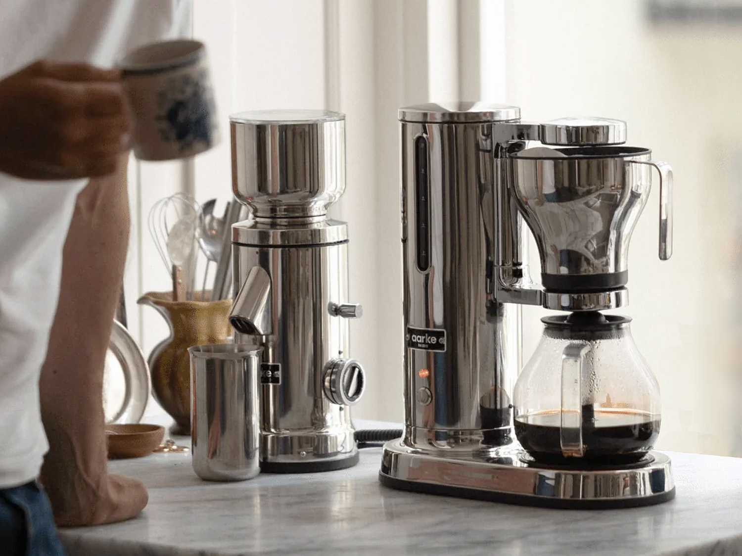 An automatic drip coffee maker brewing a fresh pot of coffee in a bright kitchen